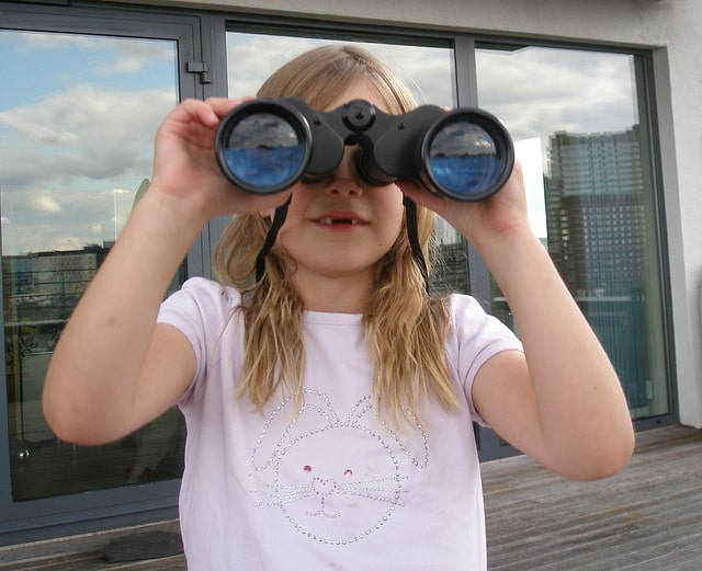 small child looking through binoculars