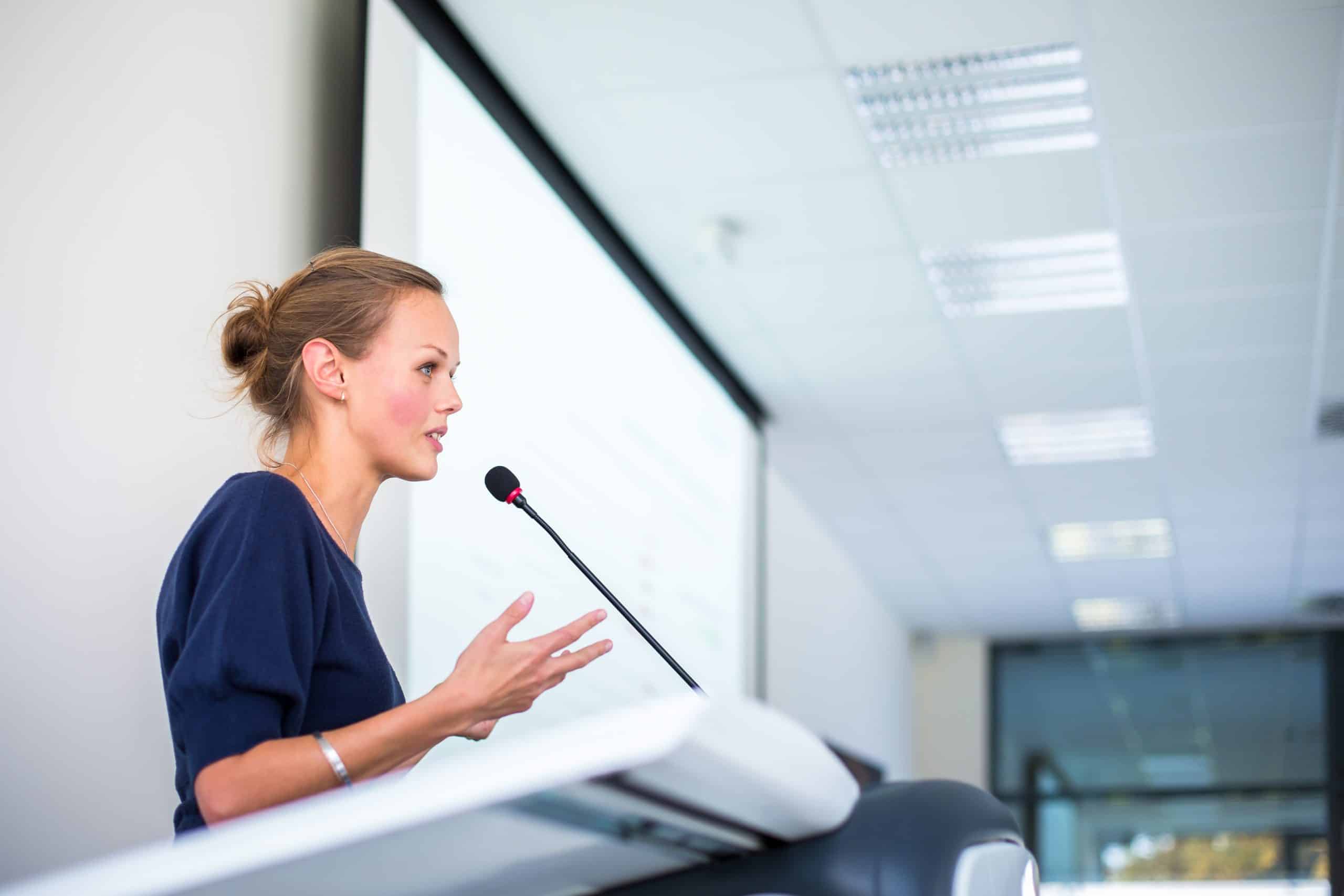 young business woman giving a presentation in a conference/meeting setting